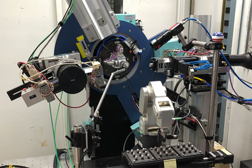 High-throughput synchrotron powder X-ray diffraction equipment in a radial shape with various mechanical arms, including “plasma sealing” glass capillaries in a nitrogen glovebox.